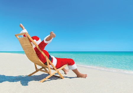 Christmas Santa Claus Enjoy Sun On Deckchair At Sandy Beach